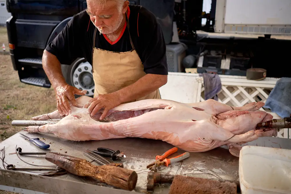 butcher with dead carcass