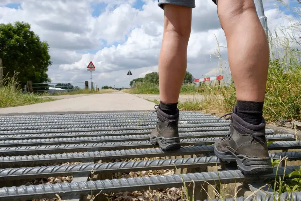 man walking on metal cattle guards